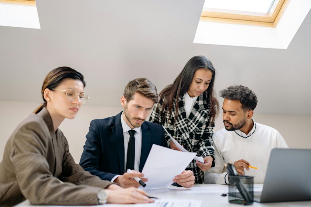 Diverse team working together in an office, discussing documents and strategies.